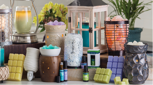 Wax warmers, a Himalayan salt lamp, essential oils and wax melts displayed together on a counter