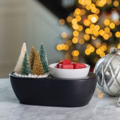 Bottle Brush Tree ArtScents Wax Warmer with a blurry  Christmas tree lit up in the background.