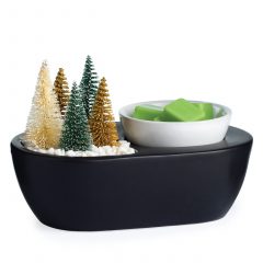 Bottle Brush Tree ArtScents Wax Warmer with a blurry  Christmas tree lit up in the background.