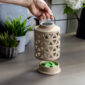 The Geo Canopy Illumination Warmer is a decorative, stylish, and simple warmer that will complement your home décor. This top-down wax warmer features a metal handle and a halogen light bulb for melting fragranced wax melts. It has an elegant circular shape with a geometric pattern that adds interest to any room.