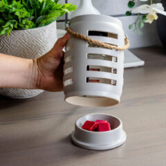 Add beautiful fragrance to your room with the Shutter Lantern Canopy Illumination Warmer. The stunning lantern features a shutter motif and rustic rope handle. A halogen bulb warms wax melts in the warming dish from the top down releasing fragrance into your home.