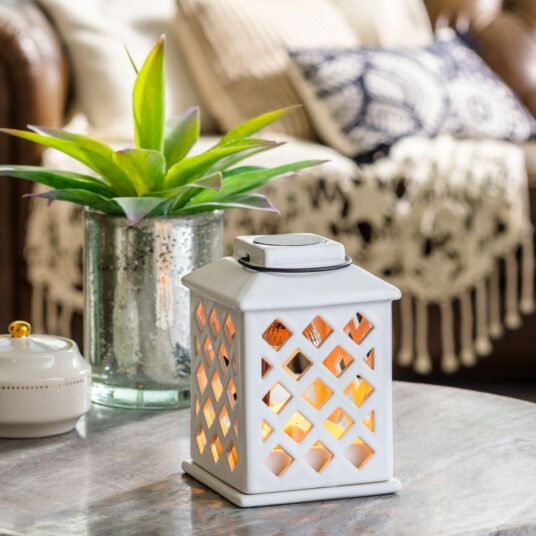 Add a touch of elegance to your home with the Trellis Lantern Canopy Illumination Warmer. Inspired by on-trend trellis patterns, this elegant warmer features a metal handle and is accented with a halogen bulb that warms wax melts in the warming dish to fill large areas with fragrance.
