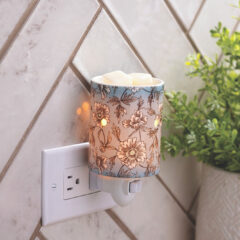 Give your home a breath of fresh air with the Flora Pluggable Fragrance Warmer. The powdered robin's egg blue and vintage floral print of this ceramic wax warmer will uplift your spirit and infuse your home with fragrance of your choice. This bohemian-inspired warmer makes a thoughtful gift for the free-spirited.