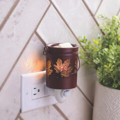 Welcome autumn home with the Fall Leaves Pluggable Fragrance Warmer. The detail on this vessel brings gorgeous fall style to any room with its deep maroon color and cutouts shaped like drifting leaves. Just plug it in and let the dish gently melt wax melts to infuse your space with seasonal scents. As the bulb warms your faborite wax metls, enjoy the beautiful glow reminiscent of cozy sweaters and crisp fall days.
