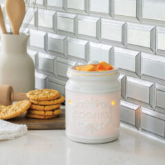 Bring the warmth of home baking to your space with our Classic Cookie Jar Fragrance Warmer. Inspired by the timeless charm of beloved home cookie jars, this white porcelain fragrance warmer combines nostalgic elegance with modern functionality, making it a perfect addition to any space. Crafted with meticulous attention to detail, this fragrance warmer features the word