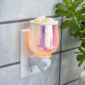 Elevate your aesthetic with the Iridescent Glow Pluggable Warmer. Its vibrant, iridescent finish and raindrop design create a soft, colorful glow while gently warming your favorite fragrances. The compact, plug-in design is perfect for small spaces, adding both style and soothing scents to any room.