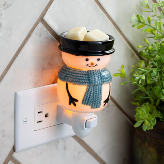 Bring winter’s magic indoors with the Snowy Pluggable Fragrance Warmer. This adorable snowman wears a classic black top hat and a cozy blue scarf, transforming any outlet into a source of fragrant bliss and gentle, warm light. Perfect for small spaces - plug in anywhere to enjoy a festive glow.