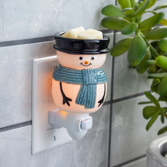 Bring winter’s magic indoors with the Snowy Pluggable Fragrance Warmer. This adorable snowman wears a classic black top hat and a cozy blue scarf, transforming any outlet into a source of fragrant bliss and gentle, warm light. Perfect for small spaces - plug in anywhere to enjoy a festive glow.