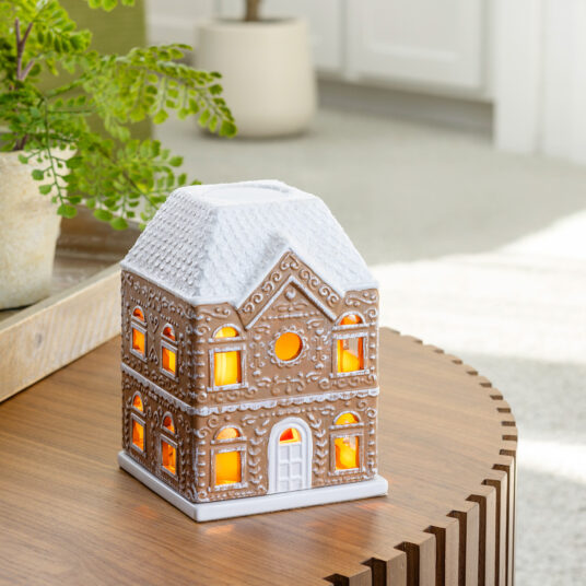 The Gingerbread House Fragrance Warmer adds holiday charm with its classic gingerbread design and cozy canopy glow. Using top-down warming technology, it gently releases seasonal scents without a flame. The perfect festive décor, it fills your home with warmth, inviting aromas, and whimsical holiday spirit.