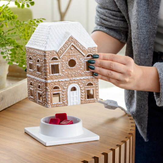 The Gingerbread House Fragrance Warmer adds holiday charm with its classic gingerbread design and cozy canopy glow. Using top-down warming technology, it gently releases seasonal scents without a flame. The perfect festive décor, it fills your home with warmth, inviting aromas, and whimsical holiday spirit.