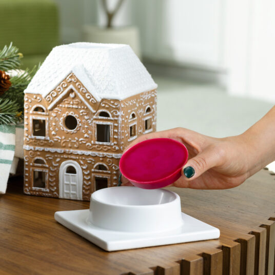 The Gingerbread House Fragrance Warmer adds holiday charm with its classic gingerbread design and cozy canopy glow. Using top-down warming technology, it gently releases seasonal scents without a flame. The perfect festive décor, it fills your home with warmth, inviting aromas, and whimsical holiday spirit.