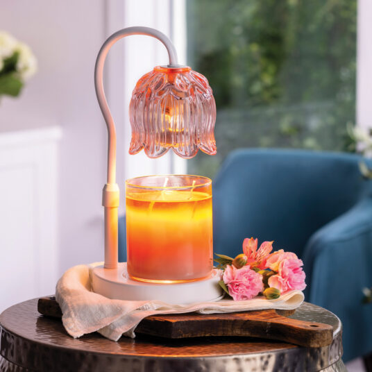 The Tulip Candle Warmer Lamp pairs a soft pink floral-shaped shade with a sleek white base for vintage-inspired elegance.