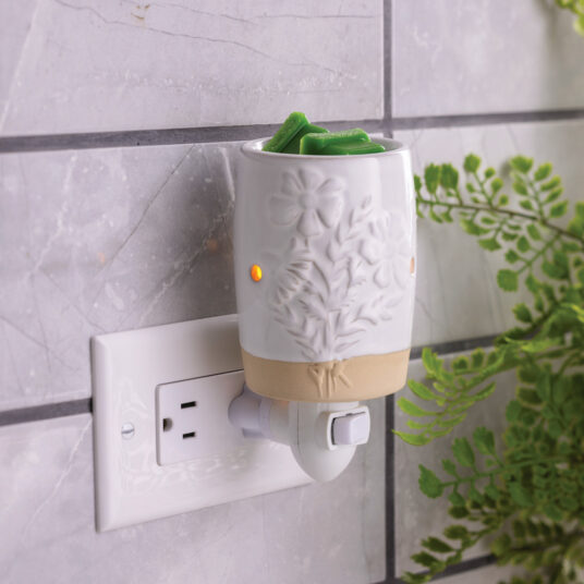 Garden Blooms Pluggable Warmer features delicate embossed floral patterns in a soft neutral palette to bring botanical charm while warming wax melts safely.