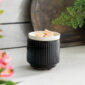 Glossy black ribbed ceramic meets a crisp white removable dish in the Noir Wax Warmer for a striking, modern silhouette that elevates contemporary decor.
