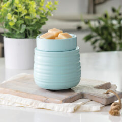 The Ruche Wax Warmer features a softly ribbed texture and light teal glaze to add subtle, modern charm to your home.