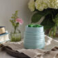 The Ruche Wax Warmer features a softly ribbed texture and light teal glaze to add subtle, modern charm to your home.